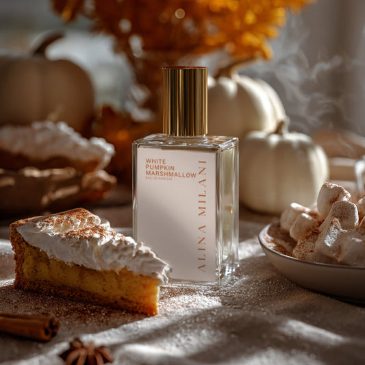 Perfume bottle labeled 'White Pumpkin Marshmallow' by Alina Milani on a table with pumpkin pie, marshmallows, and autumn decorations.